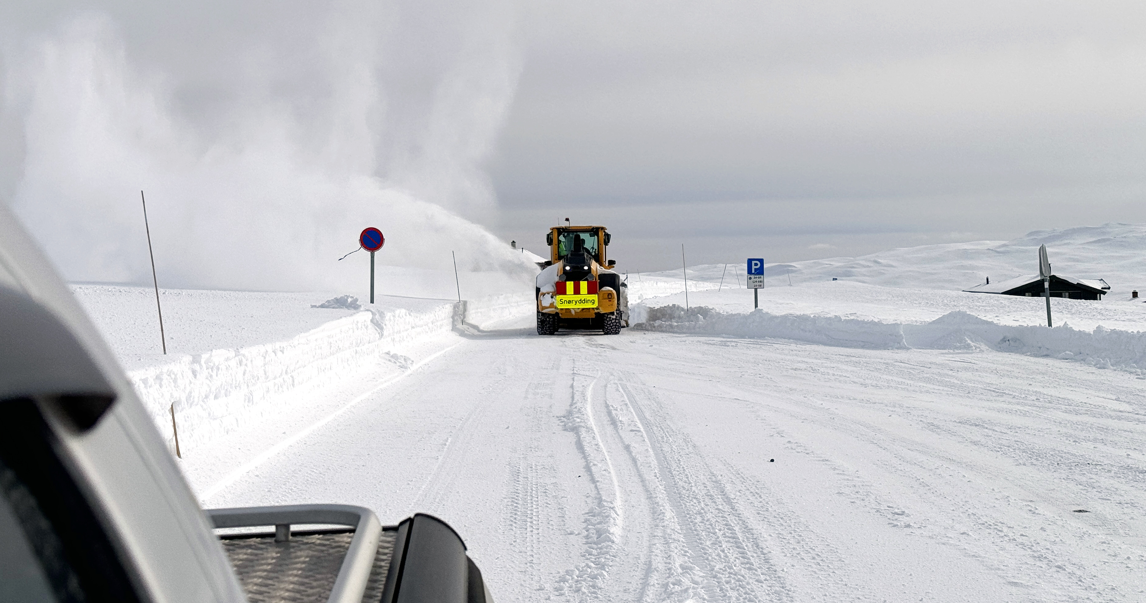 Nybrøytet veg strekker seg innover i bildet, snøfreser jobber seg innover mot midten