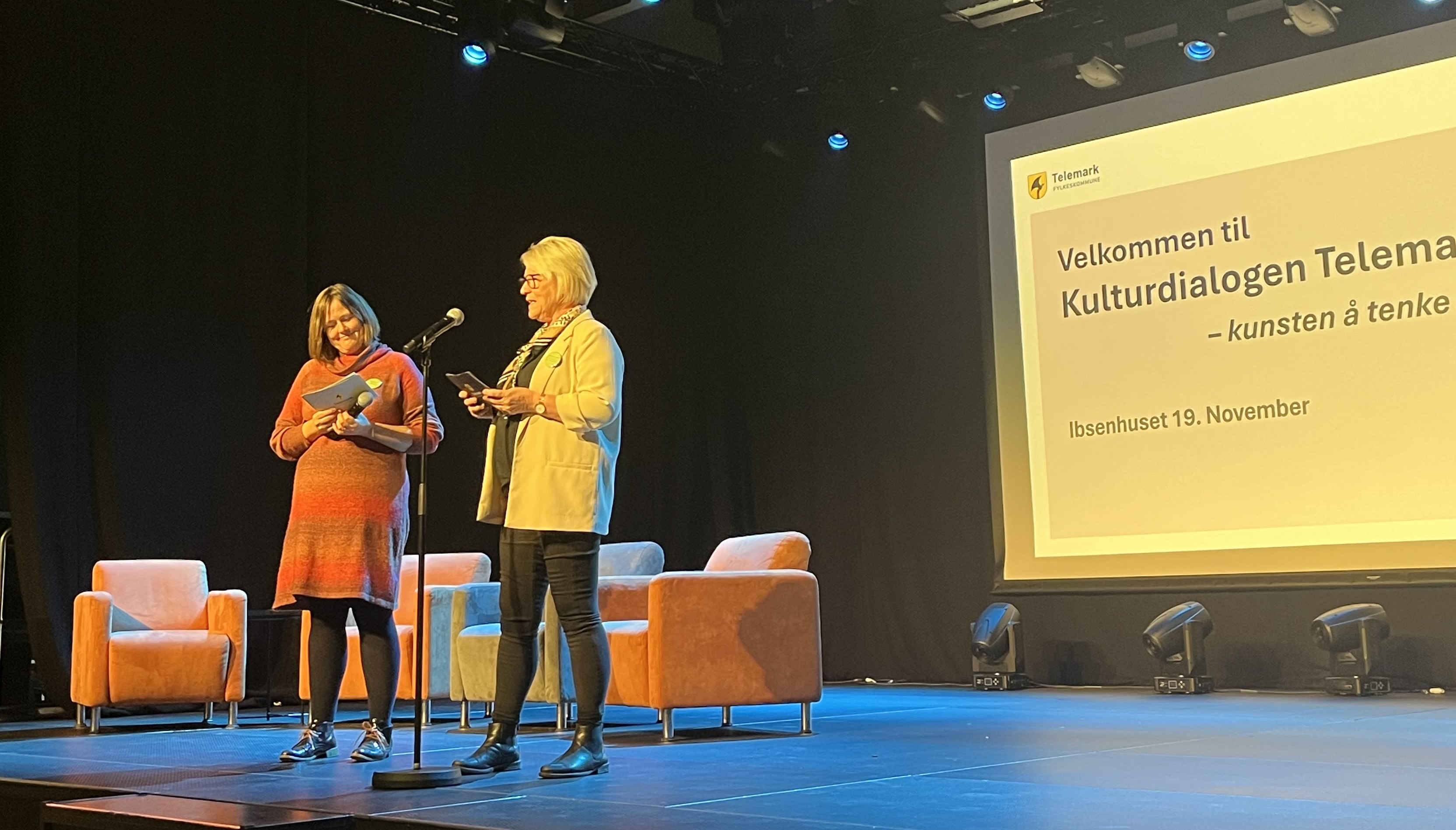 To kvinner på en scene som holder talekort