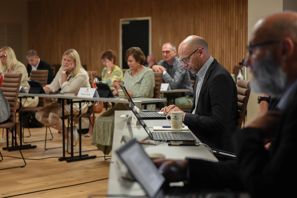 Bilde av flere mennesker i et møte som sitter og følger med. Foto.