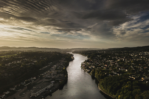 Elva mellom Skien og Porsgrunn med en himmel med lave skyer og småhusbebyggelse på begge sider.