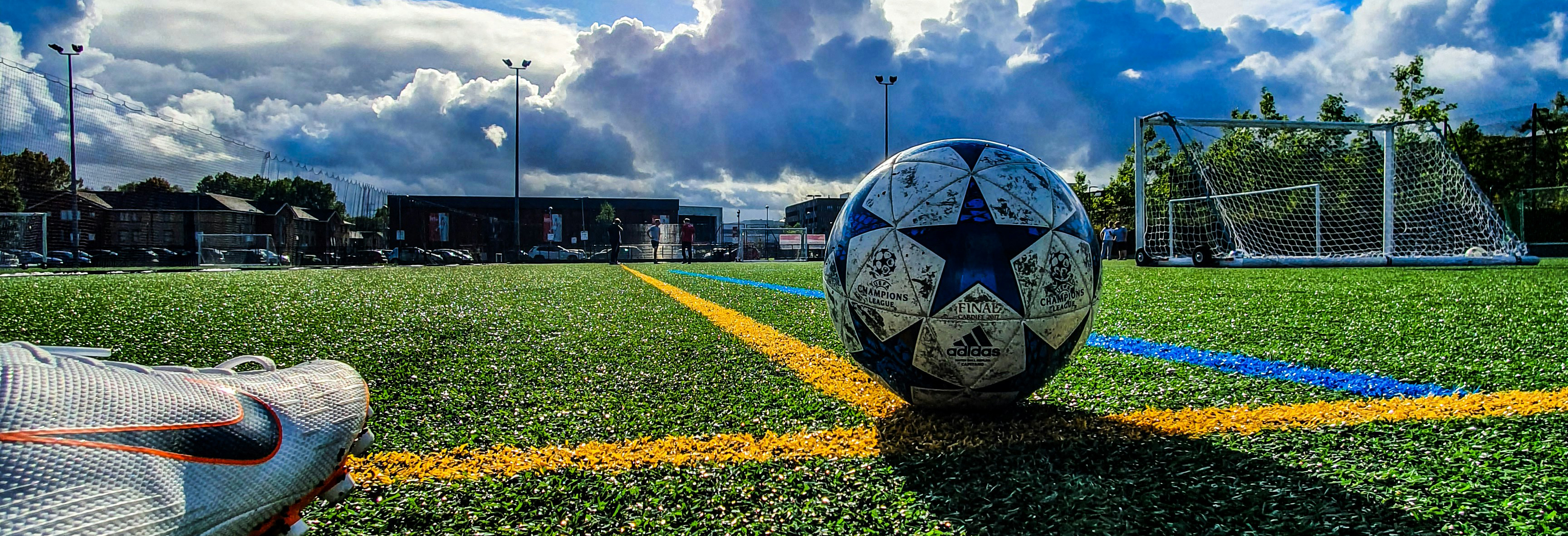Nærbilde av en fotballsko som skal sparke en fotball