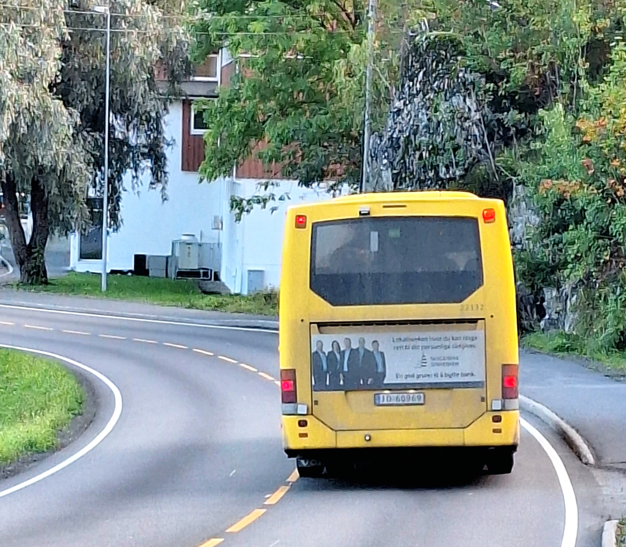 En gul fartebuss kjører på veien.