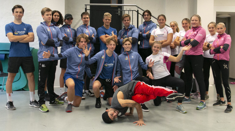 En klasse er stilt opp som et lag, og fremst står en danser og gjøre krevende "breaks".