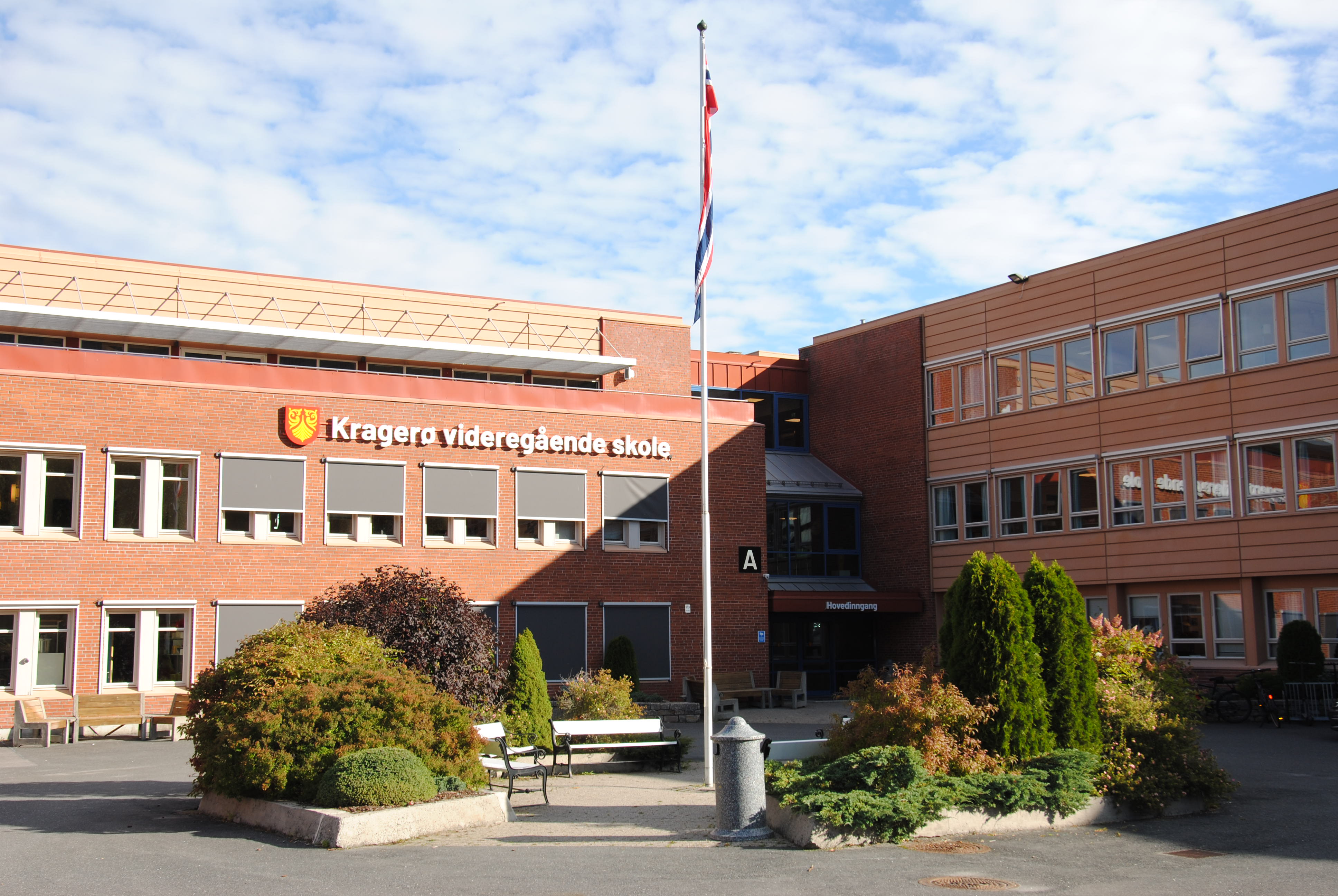Bilde av skolegården og inngangspartiet.